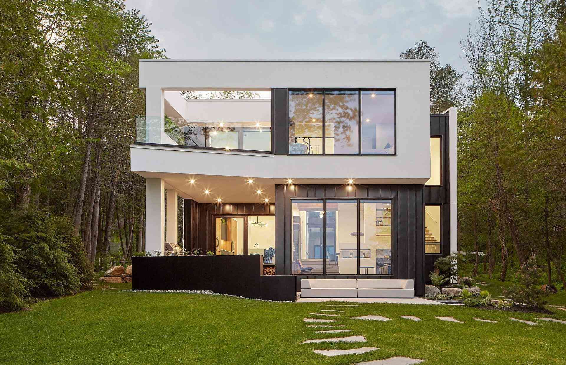 Portes et fenêtres résidentielles — Fenêtres F.E.L. Maison moderne aux grandes fenêtres noires entourée d'arbres